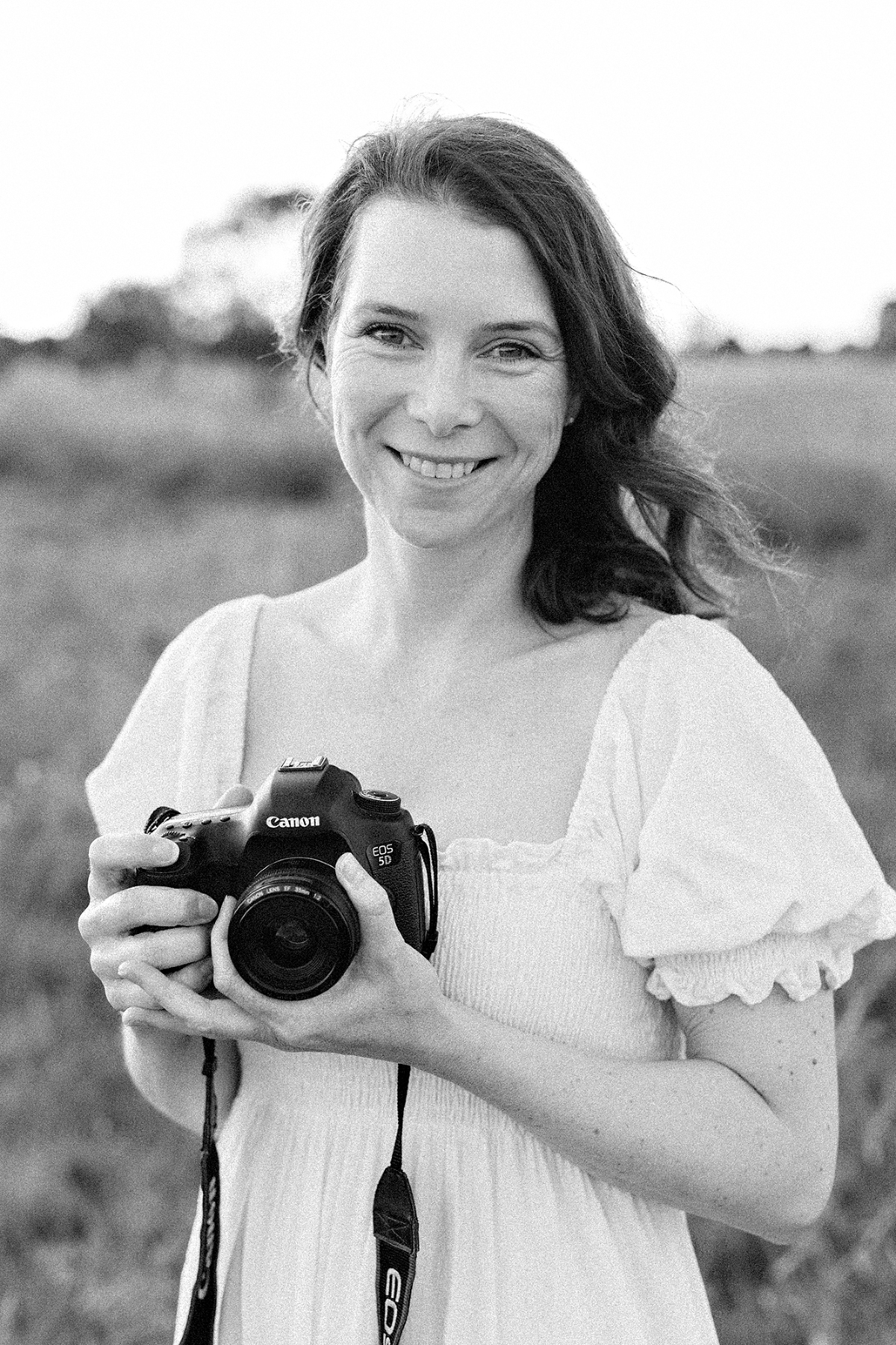 woman holding a camera in a field